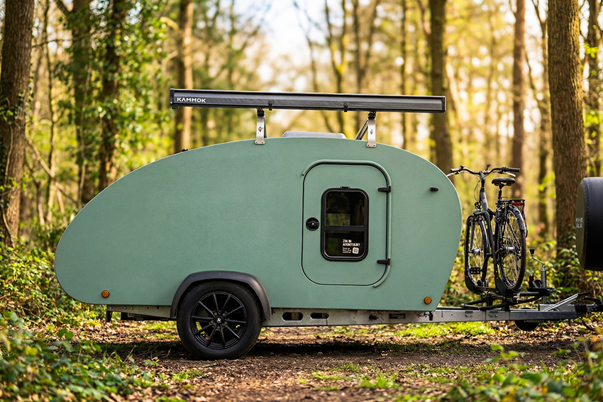 een teardrop minicaravan in een bos