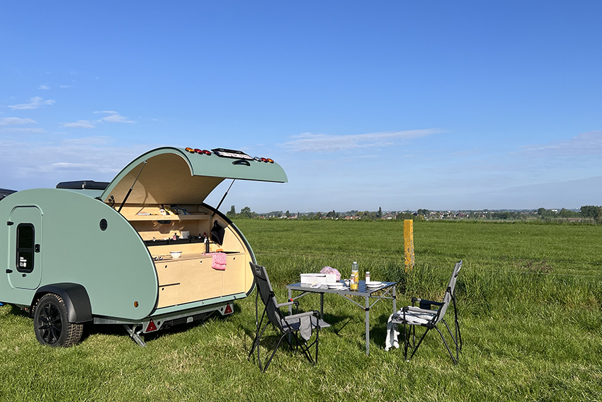 picknick in de wei aan een teardrop minicaravan